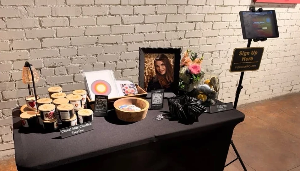 The gallery welcome table with candles, art prints and flowers.