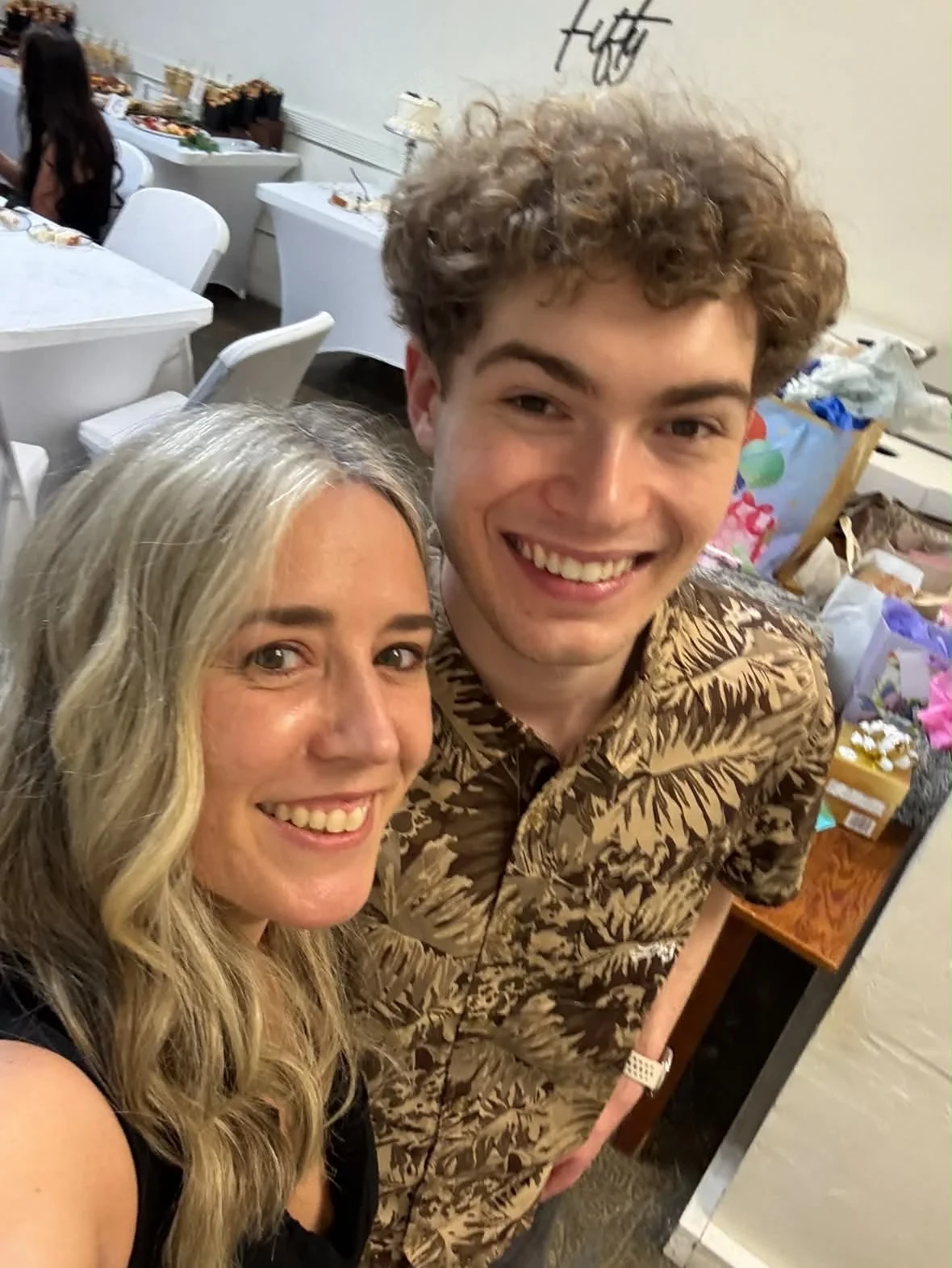 Two guests smiling for a selfie at the celebration.