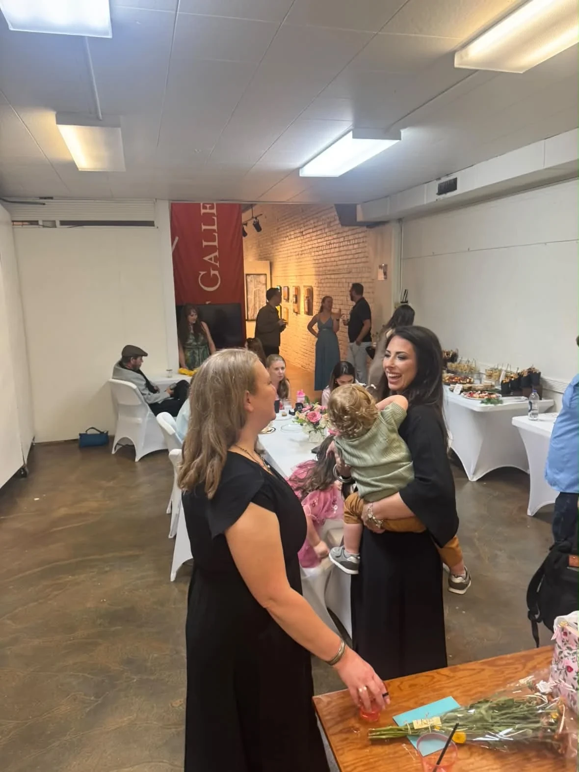 Guests and children enjoying the celebration near the refreshment tables.